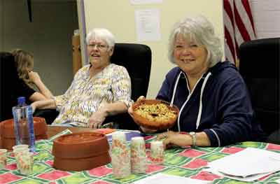 Jana Leavitt and Pat Leavitt show off their bounty at a display on sprouting during the Emergency Preparedness Fair held last week at the Overton Community Center. PHOTO BY MAGGIE MCMURRAY/Moapa Valley Progress.