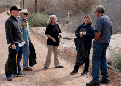 County Commissioner Marilyn Kirkpatrick (2nd from right) takes a moment from picking up trash to speak with residents of the area about flood control issues during a Clean Up Project on Saturday near the Lewis Ave. crossing of the Muddy River. PHOTO BY VERNON ROBISON/Moapa Valley Progress.