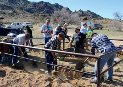 A group of area residents work with shovels to fill in the grave of Art Coleman after his remains were returned to the site on Saturday. PHOTO BY MAGGIE MCMURRAY/Moapa Valley Progress.