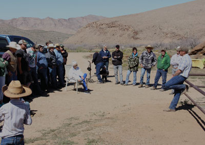 Logandale resident Dustin Nelson (leaning against the fence right) gives a eulogy during a re-dedication service at the graves of Art Coleman and Bill Garrett held on Saturday at the Gold Butte townsite. PHOTO BY VERNON ROBISON/Moapa Valley Progress.