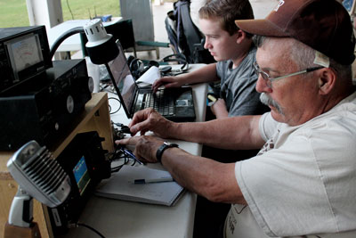 Don DeCarria (right) and Logan Gollahan communicate through a HAM radio using Morse Code during the national Amateur Radio Field Day event held last week. PHOTO BY BRYNNE MCMURRAY/Moapa Valley Progress.