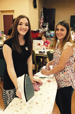 Local teens Ashley Jourdan (left) and Maylee Eide take ironing duty during the Days For Girls service project last week. PHOTO COURTESY OF LORRI RUST