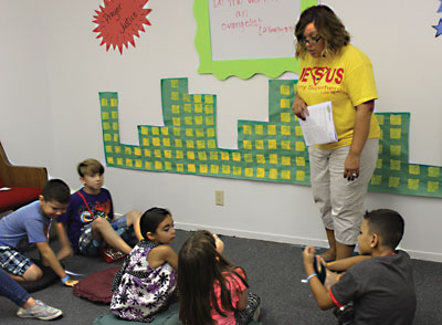 Volunteer Allison Coble teaches a group of kids stories from the bible at the Vacation Bible Camp. PHOTO BY BRYNNE MCMURRAY/Moapa Valley Progress.