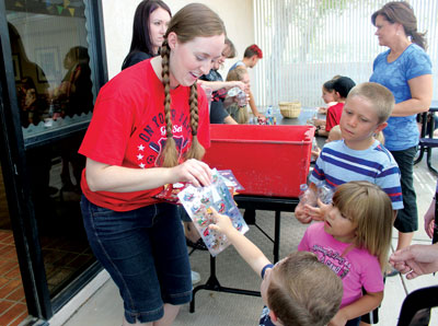 Librarian Katie Muns helps kids to pick out stickers to decorate their night sky bottles during the Summer Reading Program at the Moapa Valley Library on Friday. PHOTO BY BRYNNE MCMURRAY/Moapa Valley Progress.