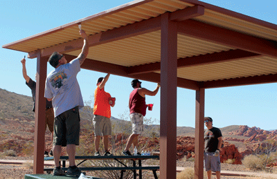 Volunteer paint the shade structures at the Logandale Trails area during a Public Lands Day event on Saturday. PHOTO BY MAGGIE MCMURRAY/Moapa Valley Progress.