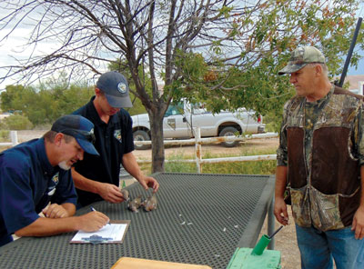 Benny Vann and Andrew Coonen tallied up the birds for hunters leaving the Overton Wildlife Management Area on the opening day of the Dove Hunt. Hunter Jim Lee (right) hunted in the Wildlife Management Area and shot 3 dove. PHOTO BY STEPHANIE BUNKER/Moapa Valley Progress.