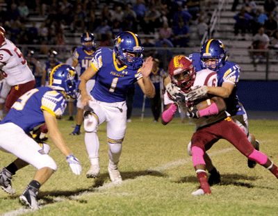 Pirate Larsen Love brings down Del Sol’s Titan Williams with backup from Trent Barlow (left) and Dalyn Leavitt (center), during a home game on Friday last week. PHOTO BY VERNON ROBISON/Moapa Valley Progress.